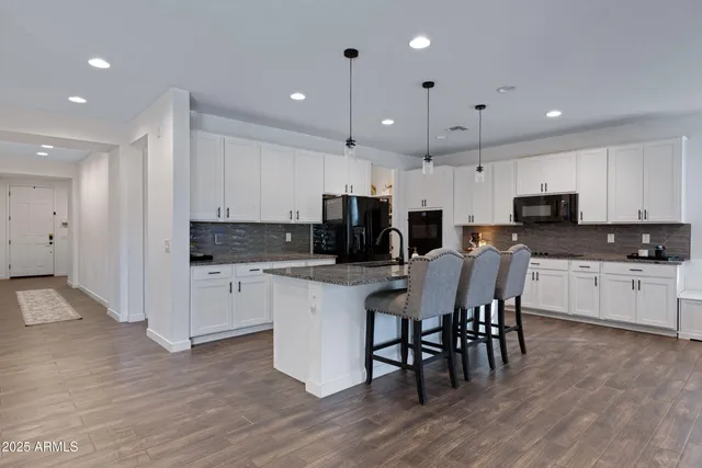 a kitchen with kitchen island granite countertop a center island stainless steel appliances and cabinets