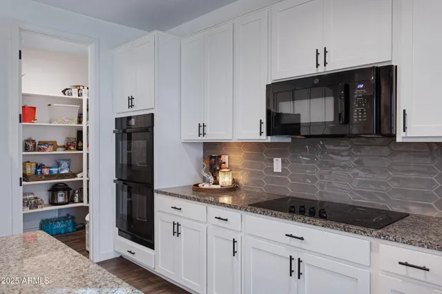 a kitchen with granite countertop a refrigerator and a sink