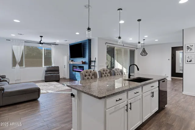 a kitchen with stainless steel appliances granite countertop a sink a stove and a wooden floor