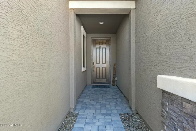 a view of a hallway with wooden floor and a bathroom