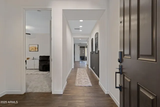 a view of a hallway with wooden floor and staircase
