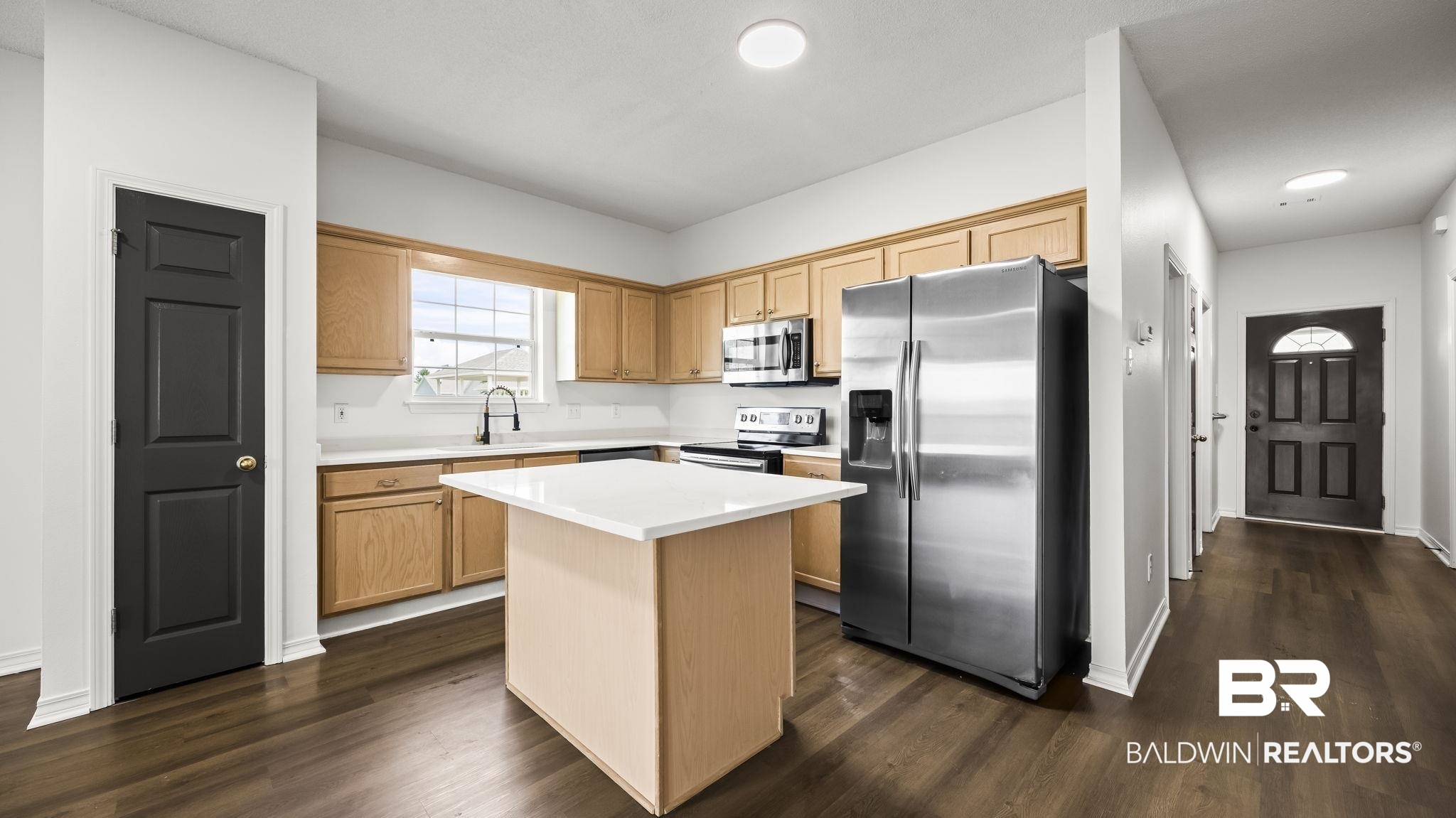 2651 South Juniper Street, Unit 705 Foley, AL 36535 - Photo 5 of 37 Kitchen featuring wood cabinetry, white subway tile backsplash, stainless steel appliances, a center island with a white countertop, and dark wood-finish flooring