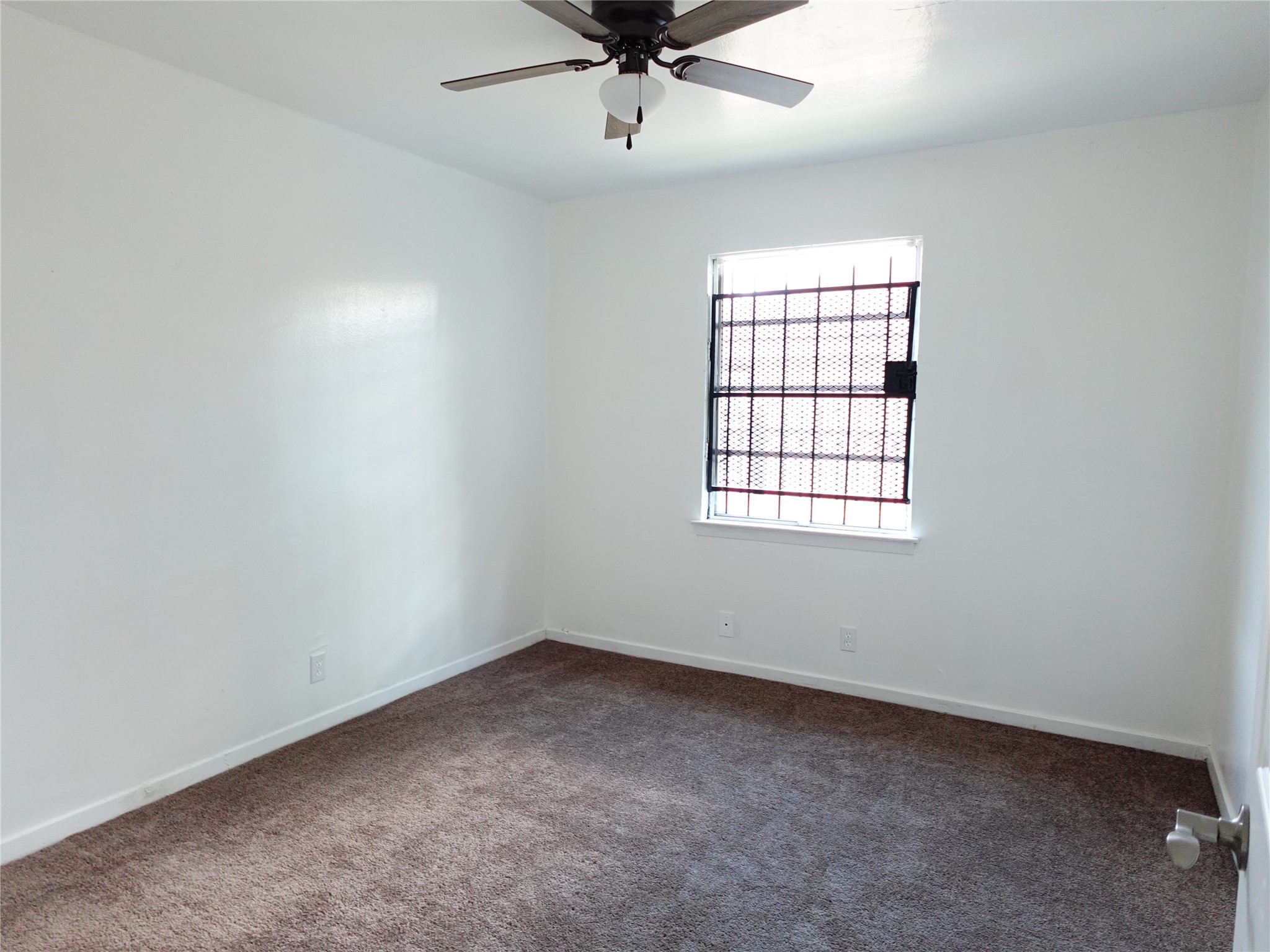 8022 Woodlyn Road Houston, TX 77028 - Photo 6 of 7 an empty room with a window and a fan