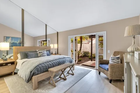 a large bedroom with a large bed and wooden floor