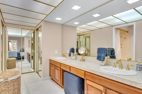 a spacious bathroom with a granite countertop sink and a mirror