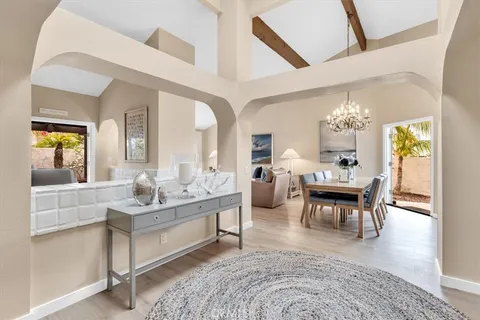 a living room with furniture a dining table and a chandelier
