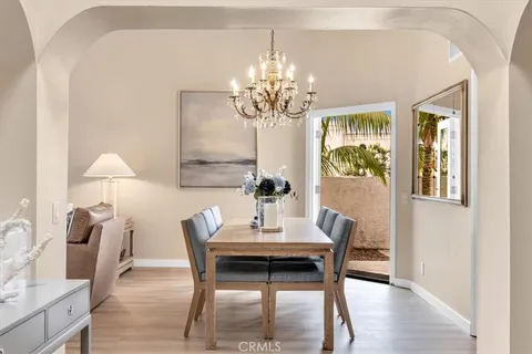 a dining room with furniture a chandelier and wooden floor