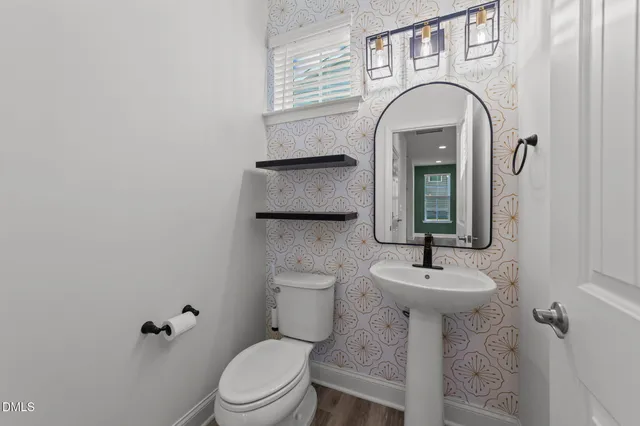 a bathroom with a toilet sink and mirror