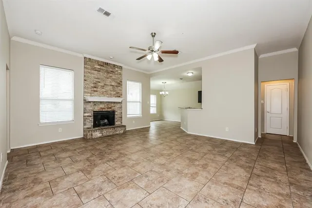 an empty room with windows and fireplace