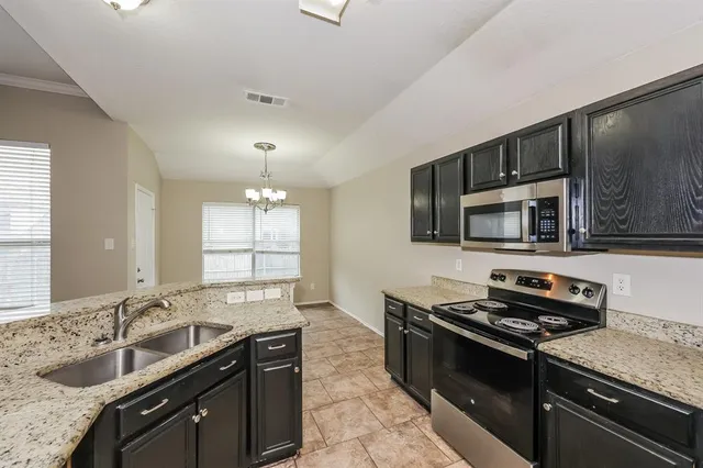 a kitchen with stainless steel appliances granite countertop a sink stove and microwave