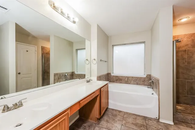 a spacious bathroom with sink shower and a bathtub