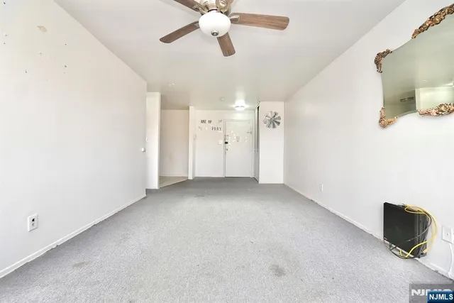 a view of a livingroom with a ceiling fan and window