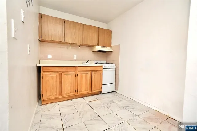 a view of a kitchen with white cabinets