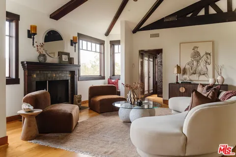 a living room with furniture fireplace and a window
