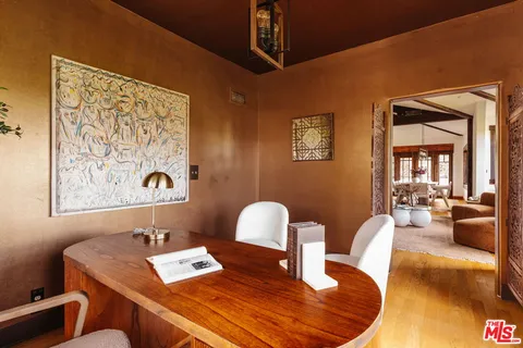a view of a hallway with wooden floor and a bathroom