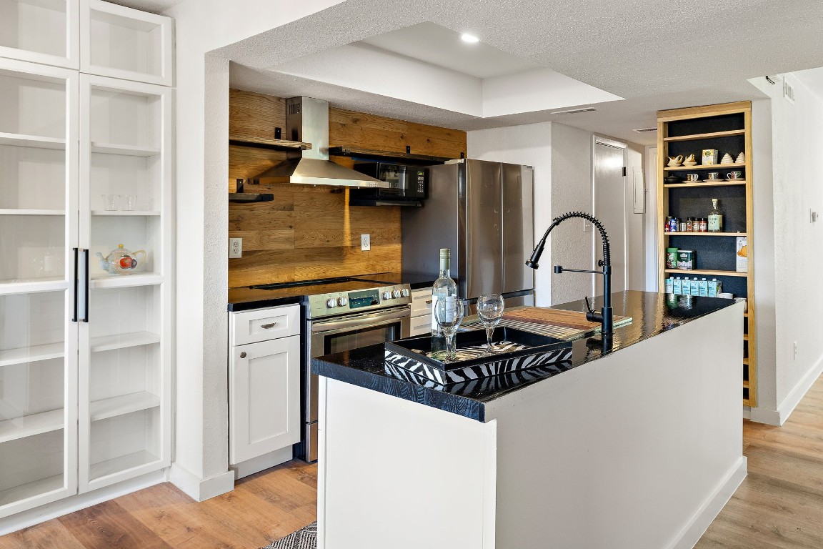 a kitchen with stainless steel appliances kitchen island a refrigerator and a stove top oven