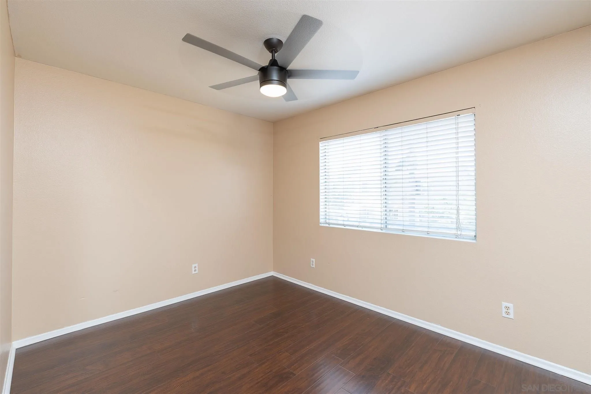 3208 Naylor Road San Diego, CA 92173 - Photo 19 of 24 an empty room with wooden floor fan and windows
