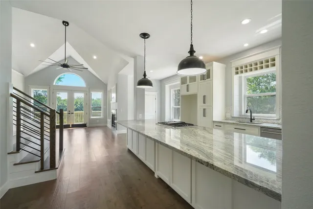 a open kitchen with granite countertop a stove and a large window