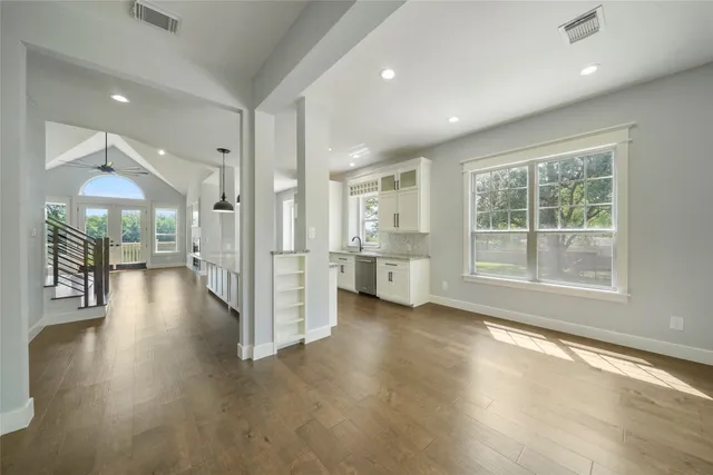 a view of a hallway with wooden floor and a kitchen