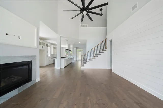 a view of an empty room with wooden floor fireplace and a window