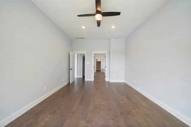 en empty room with a ceiling fan and wooden floor