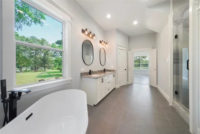 a spacious bathroom with a double vanity sink mirror and a shower