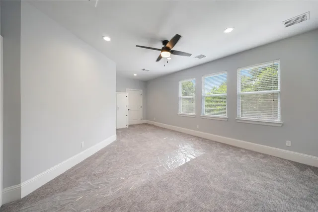 an empty room with a window and a fan