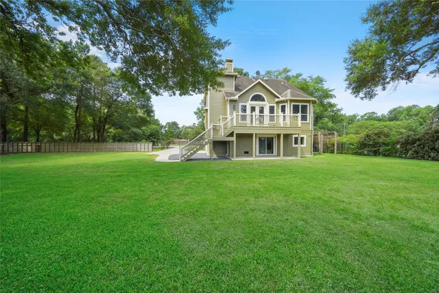 an aerial view of lake residential house with outdoor space and trees around