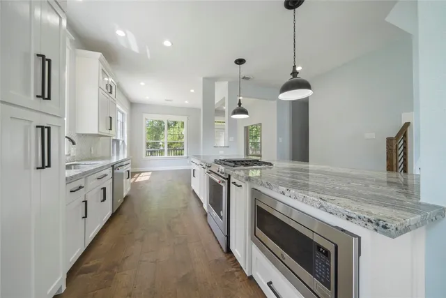 a large kitchen with granite countertop a stove and a sink