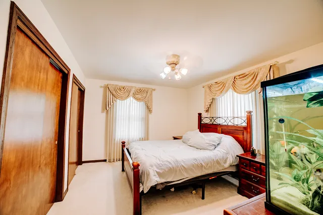 a bedroom with a bed dresser and a window