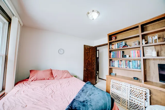 a bedroom with a bed furniture and a book shelf
