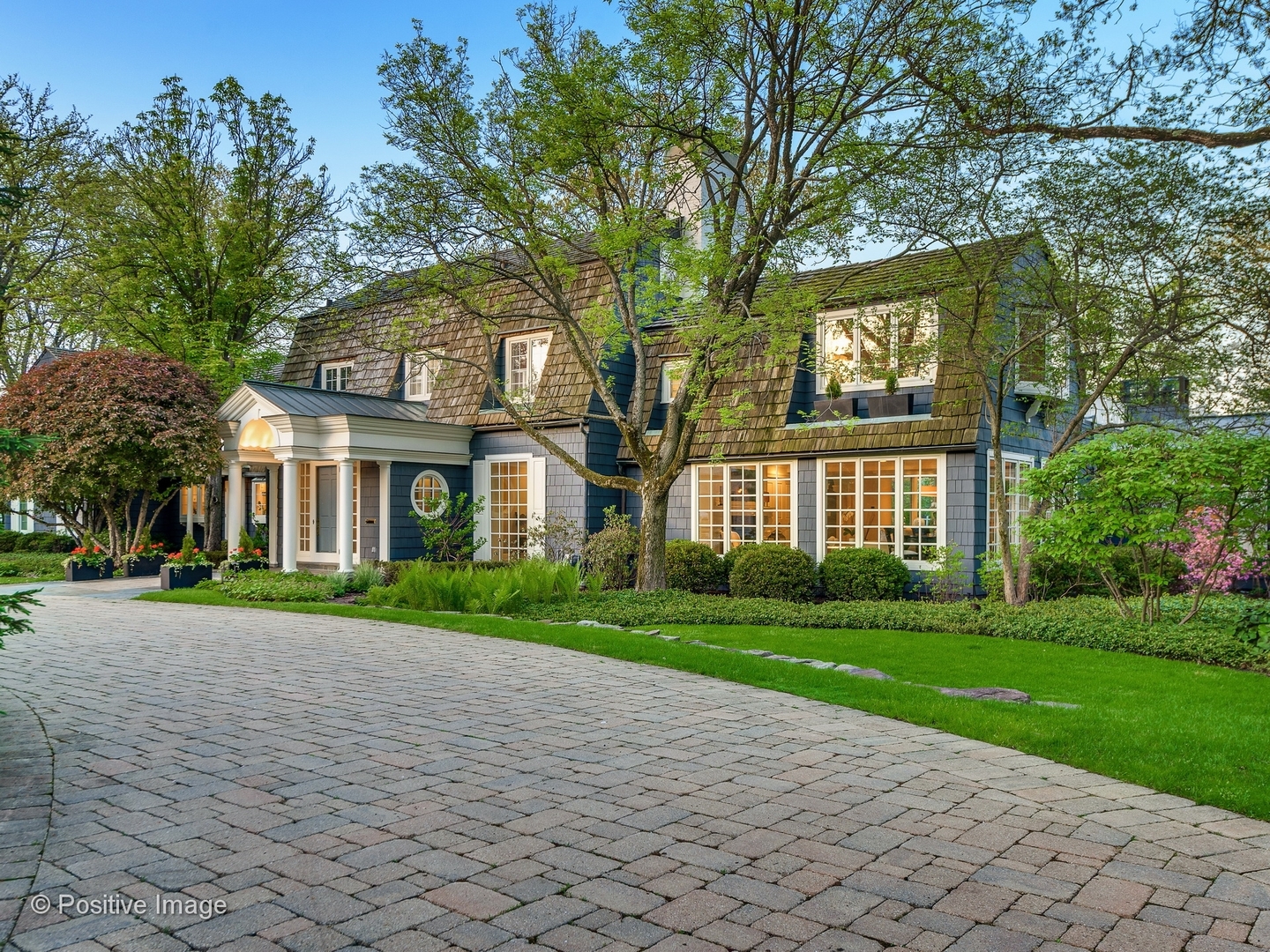 a view of a brick building next to a yard with big trees