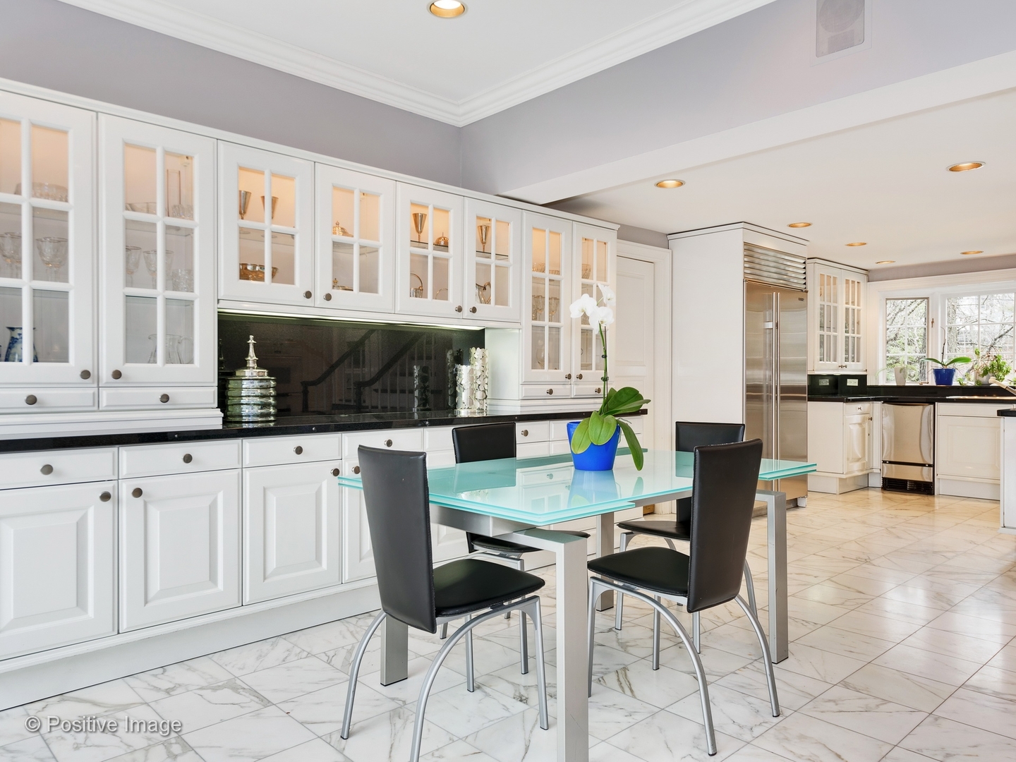 32 Indian Hill Road Winnetka, IL 60093 - Photo 19 of 79 a kitchen with stainless steel appliances kitchen island granite countertop a table and chairs in it