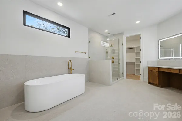 a bathroom with a tub a sink and glass door