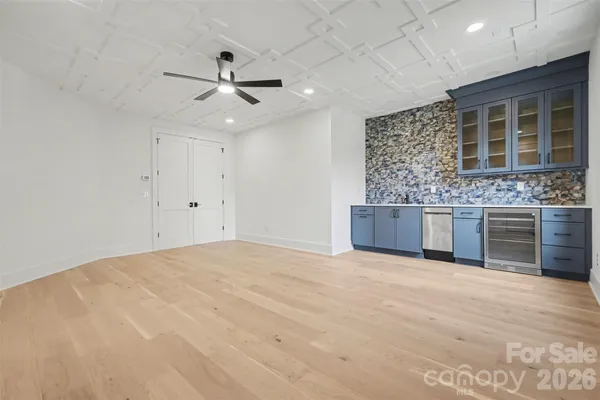 a view of empty room with wooden floor and ceiling fan