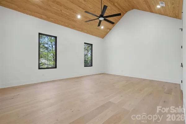 an empty room with windows and fan