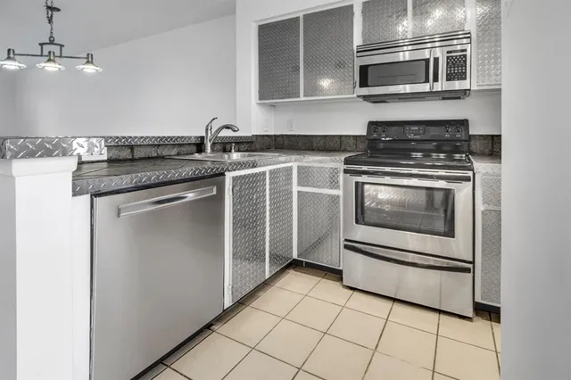 a kitchen with stainless steel appliances granite countertop a sink and a stove