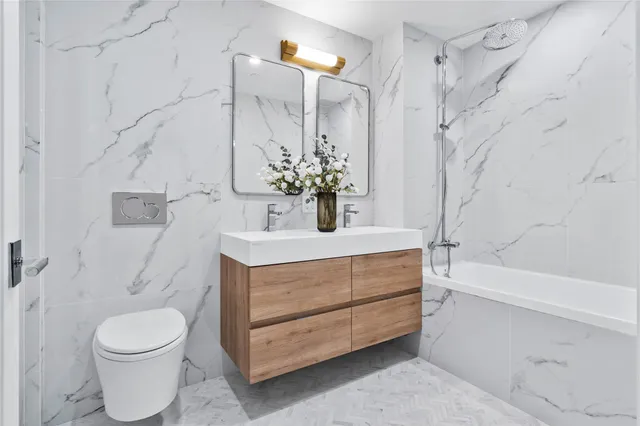 a bathroom with a sink a toilet and shower