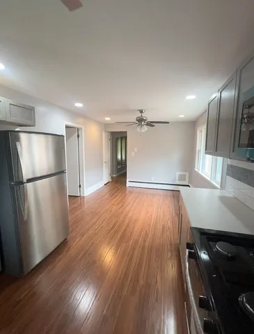 a view of empty room with wooden floor