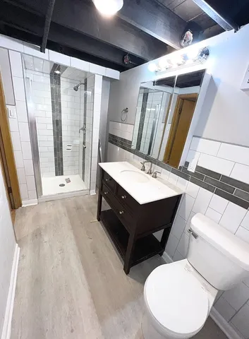 a bathroom with a double vanity sink toilet and shower