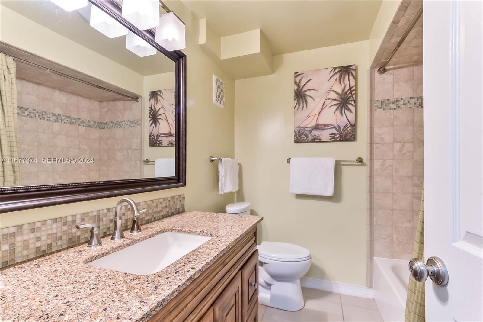 301 Racquet Club Road, Unit 108 Weston, FL 33326 - Photo 17 of 30 a bathroom with a granite countertop sink mirror vanity and toilet