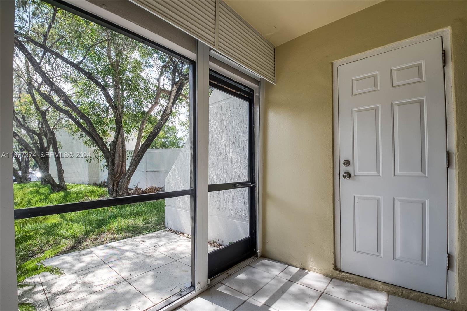 301 Racquet Club Road, Unit 108 Weston, FL 33326 - Photo 21 of 30 a view of a porch with a floor to ceiling window and a yard