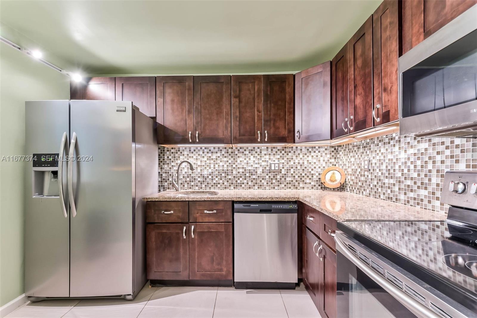 301 Racquet Club Road, Unit 108 Weston, FL 33326 - Photo 3 of 30 a kitchen with stainless steel appliances granite countertop a refrigerator and a sink