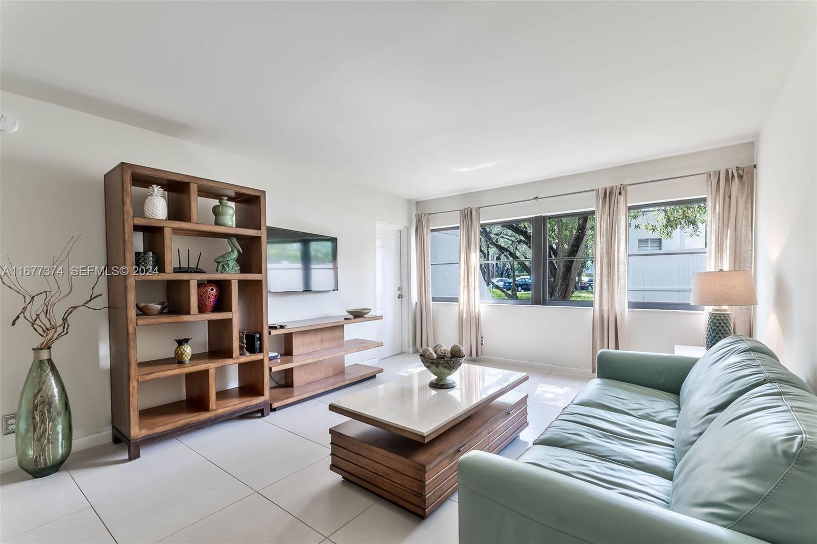 301 Racquet Club Road, Unit 108 Weston, FL 33326 - Photo 5 of 30 a living room with furniture and a book shelf