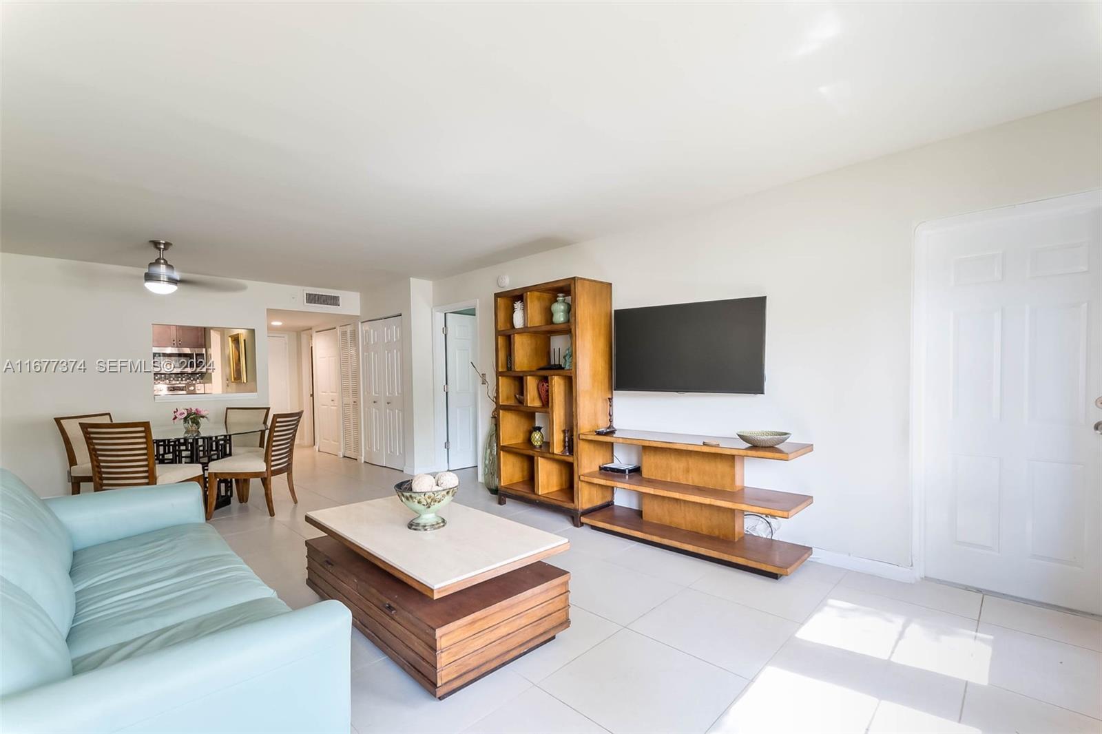 301 Racquet Club Road, Unit 108 Weston, FL 33326 - Photo 8 of 30 a living room with furniture and a flat screen tv