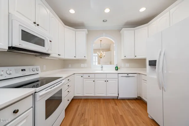 a kitchen with granite countertop white cabinets and white appliances
