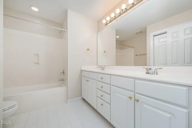 a bathroom with a tub sink and mirror