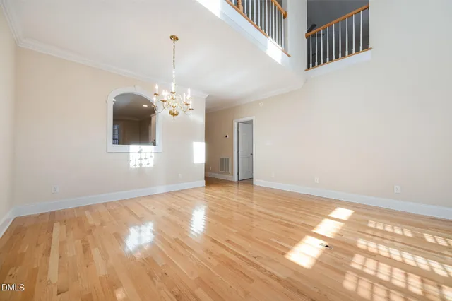 a view of a livingroom with wooden floor and a chandelier