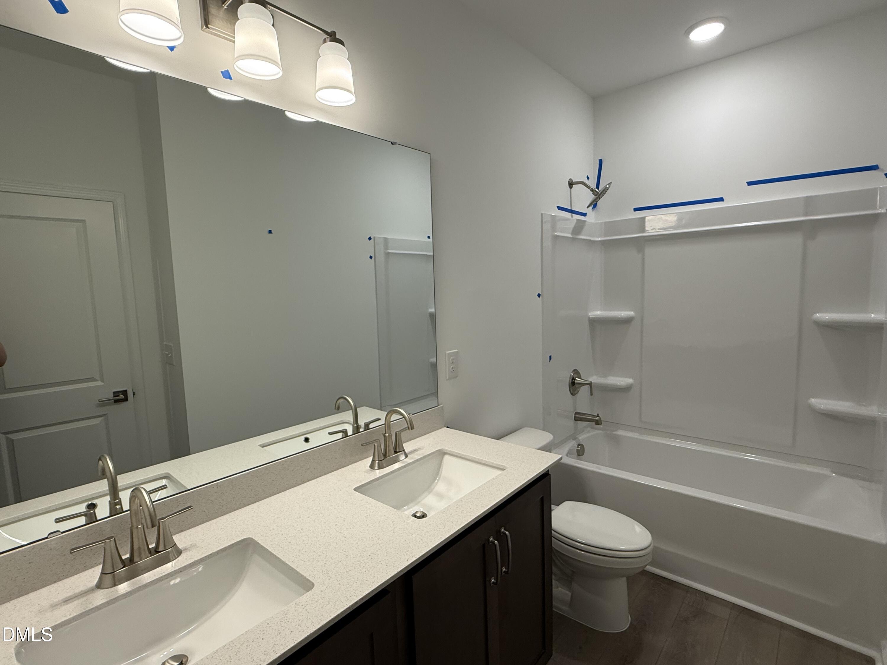 2844 Quarry Road, Unit 173 Rolesville, NC 27571 - Photo 17 of 31 a bathroom with a sink a toilet a mirror and shower
