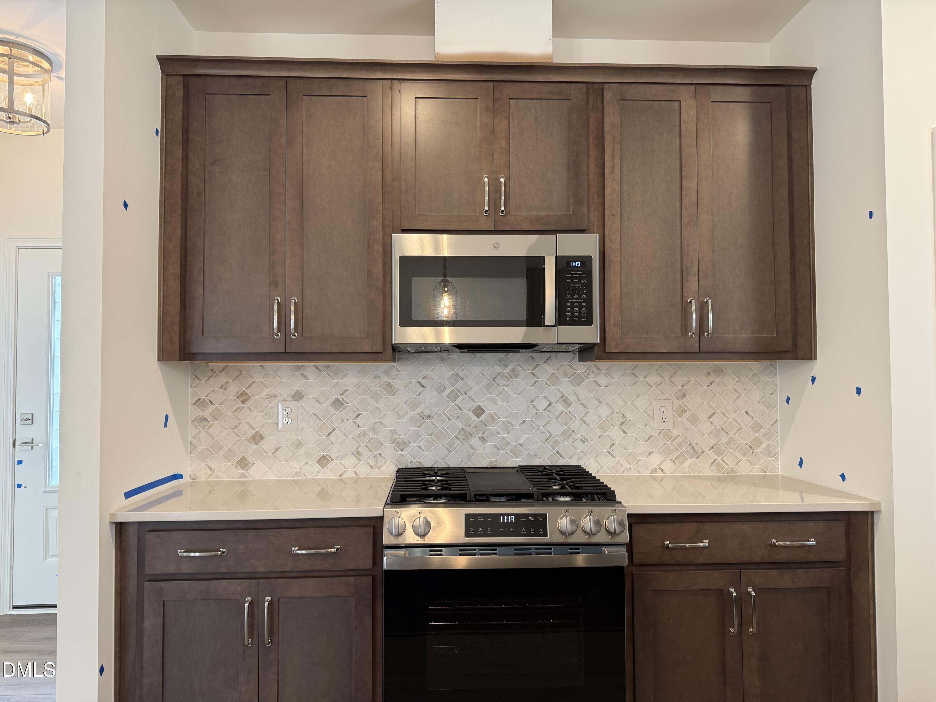 2844 Quarry Road, Unit 173 Rolesville, NC 27571 - Photo 4 of 31 a kitchen with granite countertop a stove top oven microwave and cabinets